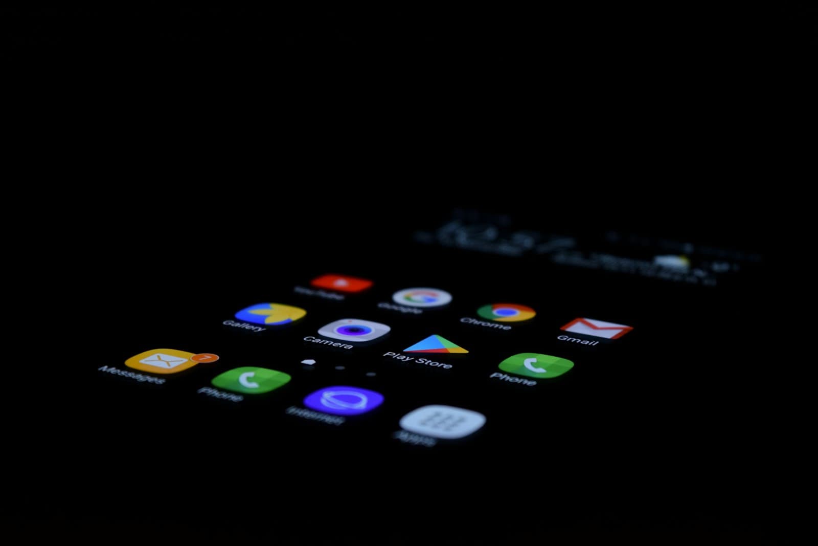 Smartphone screen glowing with app icons in a dark room
